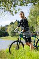Mountain biking young woman relax by lake