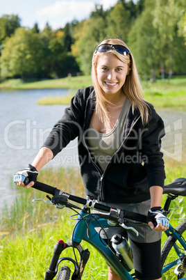 Mountain biking young woman relax by lake