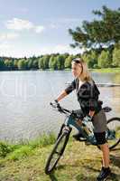 Mountain biking young woman relax by lake