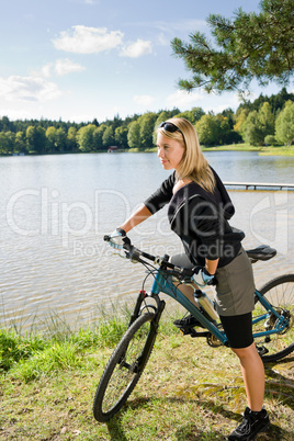 Mountain biking young woman relax by lake