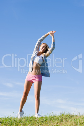 Stretching young sportive woman meadows sunny day