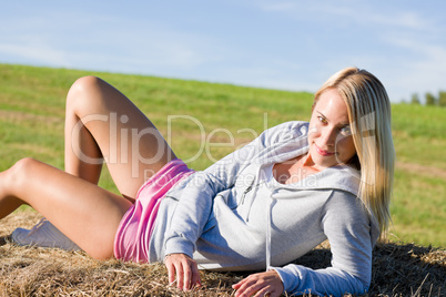 Sportive young woman relax on hay bales