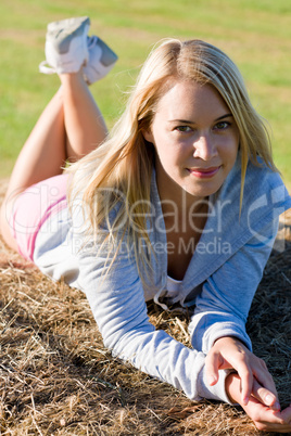 Sportive young woman relax on hay bales