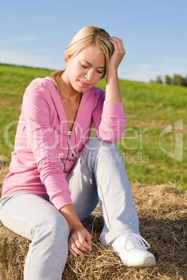 Sportive young woman relax on bales sunset