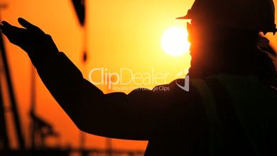 Engineer in Silhouette at Oil Production Site