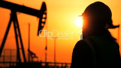 Engineer in Silhouette at Oil Production Site