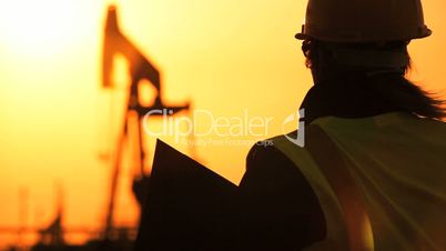 Female Engineer Overseeing Oil Production Site