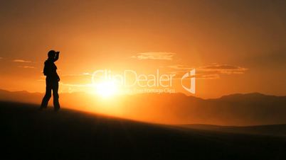 Hiker in Silhouette Completing a Desert Hike