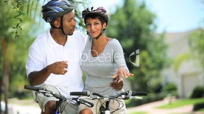 Young Healthy Ethnic Couple Cycling Together