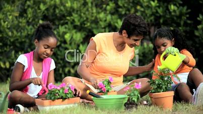 African American Girls & Their Mother Gardening Together