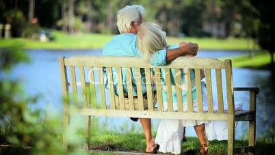 Retired Couple Sitting Outdoors on Park bench
