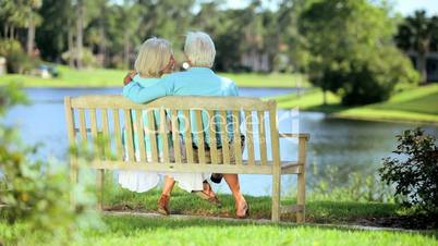Affectionate Senior Couple Relaxing on a Park Bench