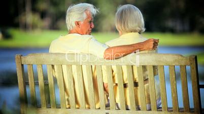 Happy Senior Couple Relaxing on Park Bench