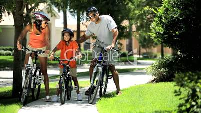 Young Ethnic Family Cycling Together