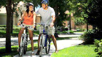 Young Healthy Ethnic Couple Cycling Together