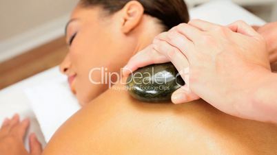 Female Spa Client Receiving Hot Stone Therapy
