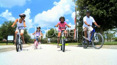 Young Ethnic Family Cycling Together