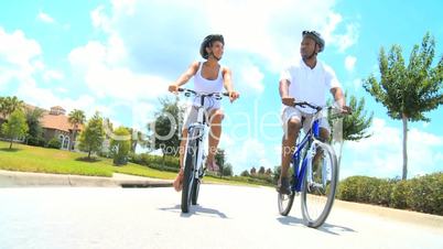 Attractive Young Ethnic Couple Cycling Together