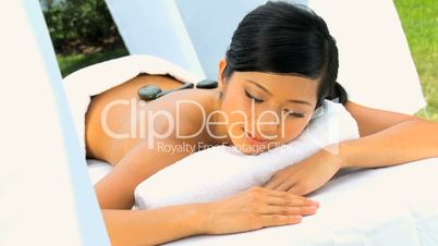 Asian Chinese Girl Relaxing with Hot Stone Massage