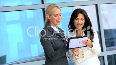 Two Businesswomen Using Wireless Technology Outdoors