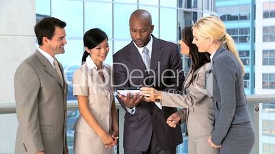 Multi Ethnic Business Team Using Wireless Tablet