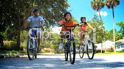 Healthy African American Family Cycling Together