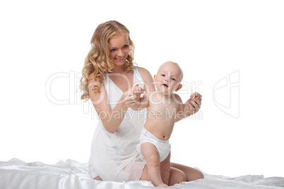 Beauty blond mother play with son in bed