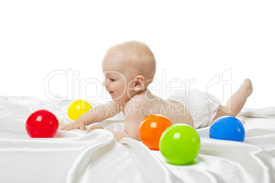 Cute baby play in bed with color balls