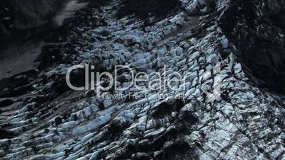 Aerial view of high mountain ridges and ash covered ice glacier, Iceland