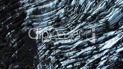 Aerial view of an Arctic glacial flow with ash blackened ice, Iceland