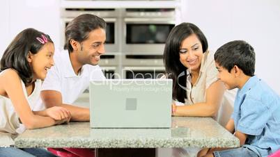 Young Ethnic Family with Laptop in Kitchen