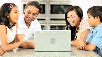 Young Ethnic Family Using Laptop for Webchat