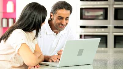 Young Ethnic Couple Online with Wireless Laptop