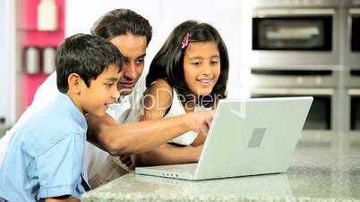 Young Ethnic Father & Children Using Laptop in Kitchen