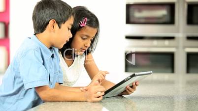 Asian Siblings Using Wireless Tablet