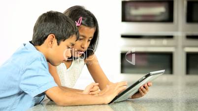 Young Asian Siblings Using Wireless Tablet