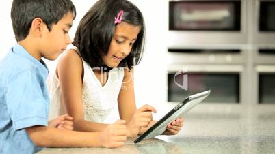 Ethnic Siblings Using Wireless Tablet
