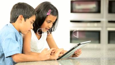 Asian Siblings Using Wireless Tablet