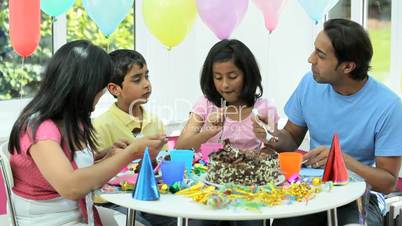 Young Asian Family Sharing Party Birthday Cake