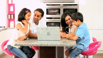 Young Asian Family Using Laptop in Kitchen