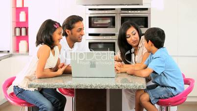 Young Asian Family with Laptop in Kitchen