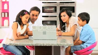 Young Asian Family Using Laptop in Kitchen
