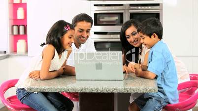 Young Ethnic Family Using Laptop for Webchat