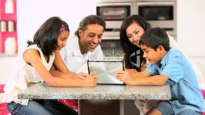 Young Ethnic Family with Wireless Tablet in Kitchen