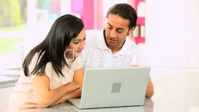 Attractive Young Ethnic Couple Using Laptop