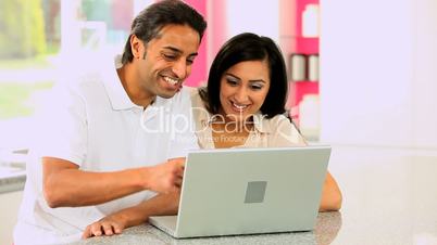 Young Asian Couple Using Laptop Computer