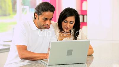 Asian Couple with Laptop Having Success Online