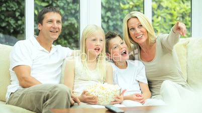 Young Family Watching Movie Together with Popcorn
