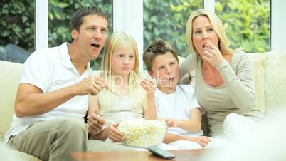 Attractive Family Enjoying TV & Popcorn