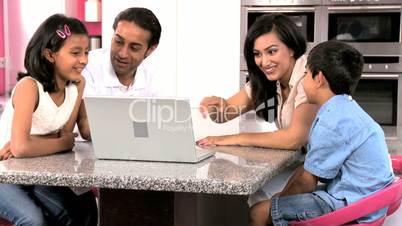 Young Ethnic Family with Laptop in Kitchen
